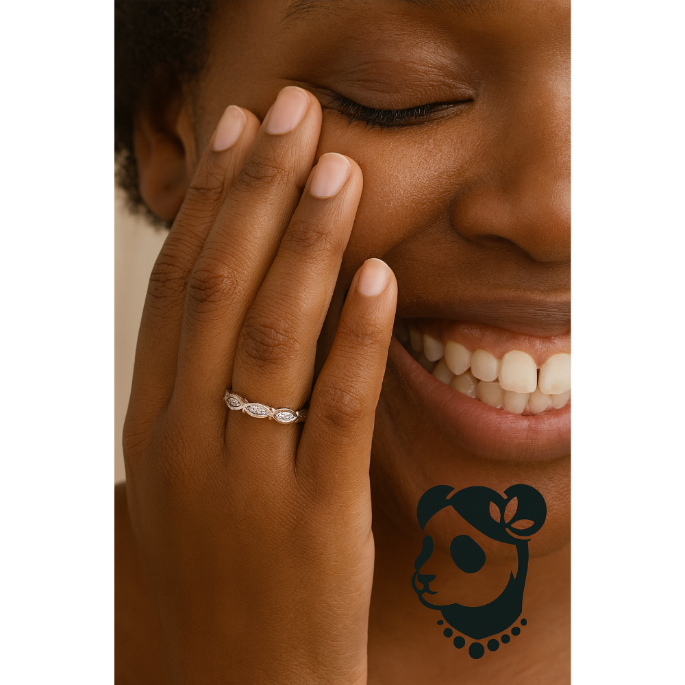 Close-up of a woman with an infinity diamond wedding band on their finger, smiling.