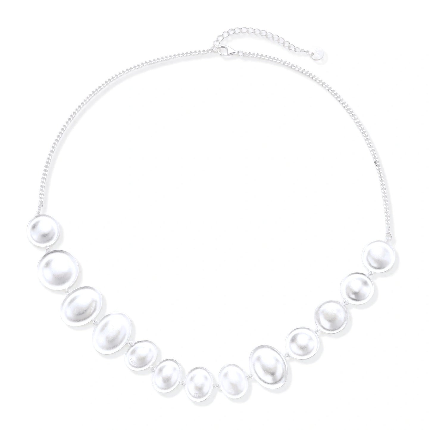 Graduated pearl-finish silver discs forming an organic bubble bib necklace on delicate chain against cream background.