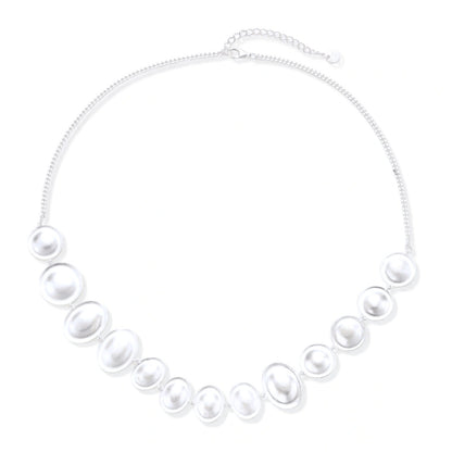 Graduated pearl-finish silver discs forming an organic bubble bib necklace on delicate chain against cream background.