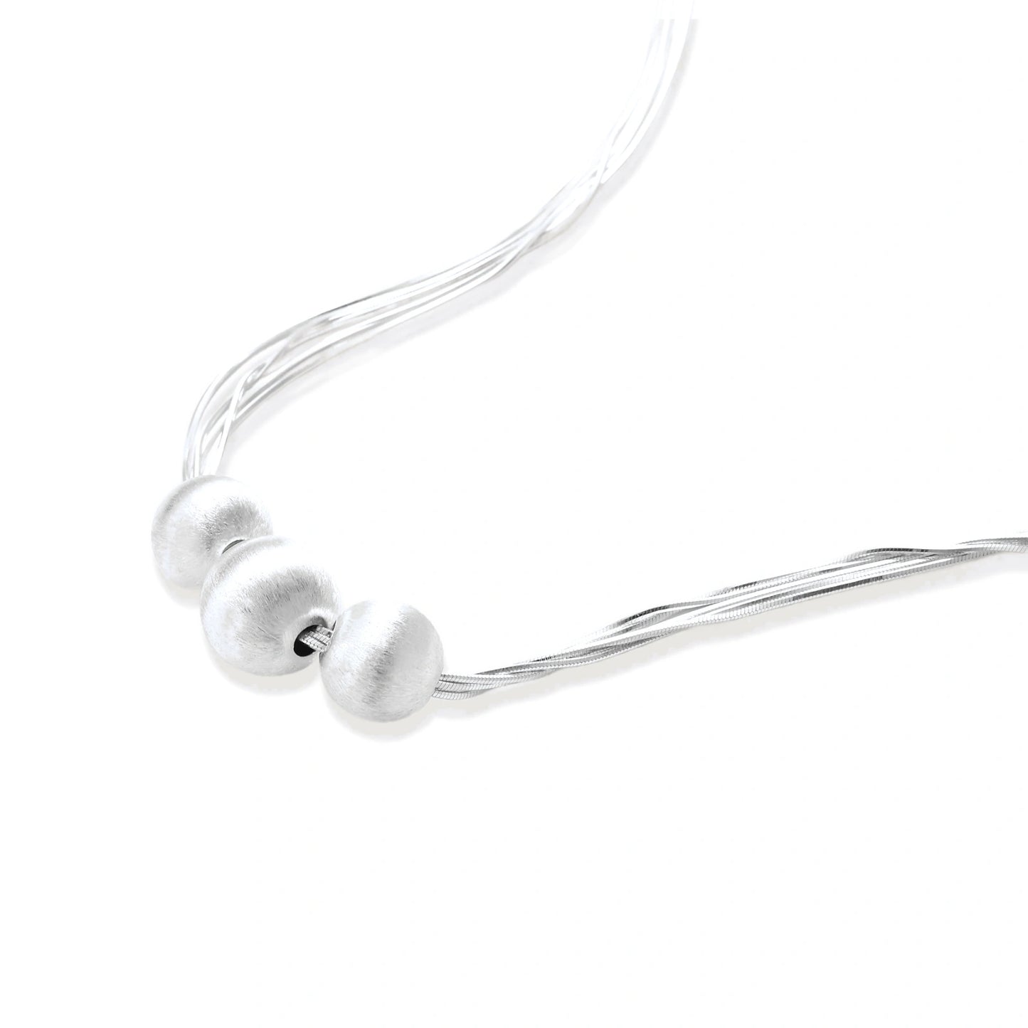 Sterling silver multi-strand necklace with three brushed round beads on cream background