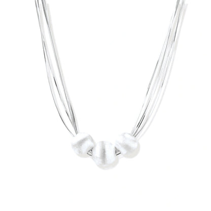 Sterling silver multi-strand necklace with three brushed round beads on cream background