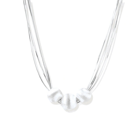 Sterling silver multi-strand necklace with three brushed round beads on cream background