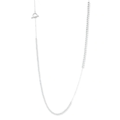 Long sterling silver beaded necklace with graduated sphere design, toggle clasp, and delicate chain extension on white background