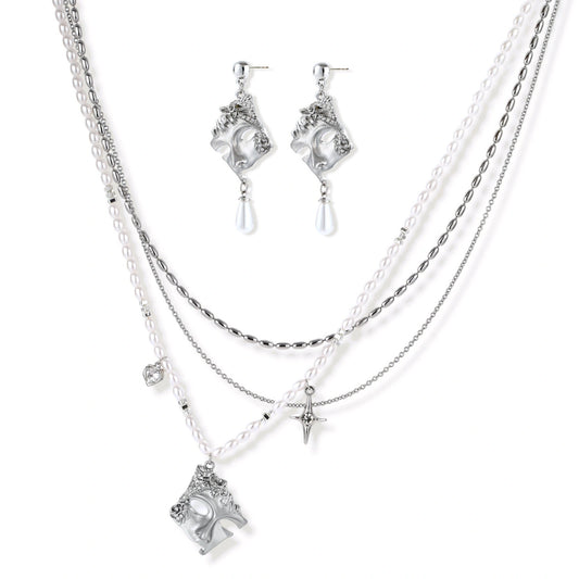 Ornate silver-toned masquerade mask jewelry set featuring rhinestone details and pearl drop earrings on white background.