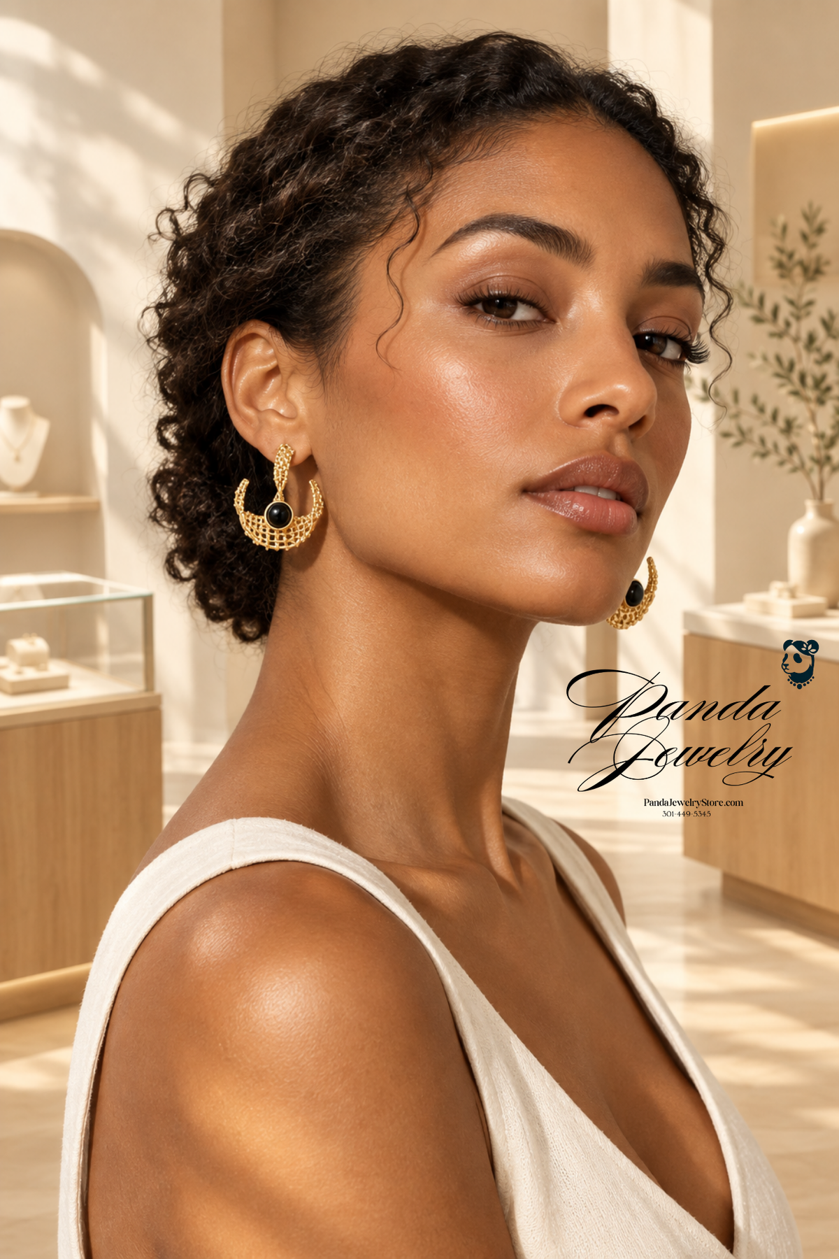 Sculptural Mesh Hoop Earrings — model wearing gold crescent mesh hoops with black resin accent in boutique