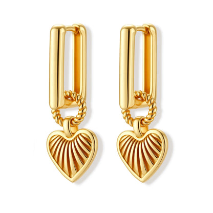 Gold-plated huggie earrings with textured heart charms featuring radiating sunburst patterns on white background.