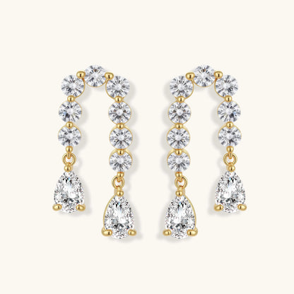 Gold-plated earrings with vertical line of clear crystals and teardrop pendants on neutral background