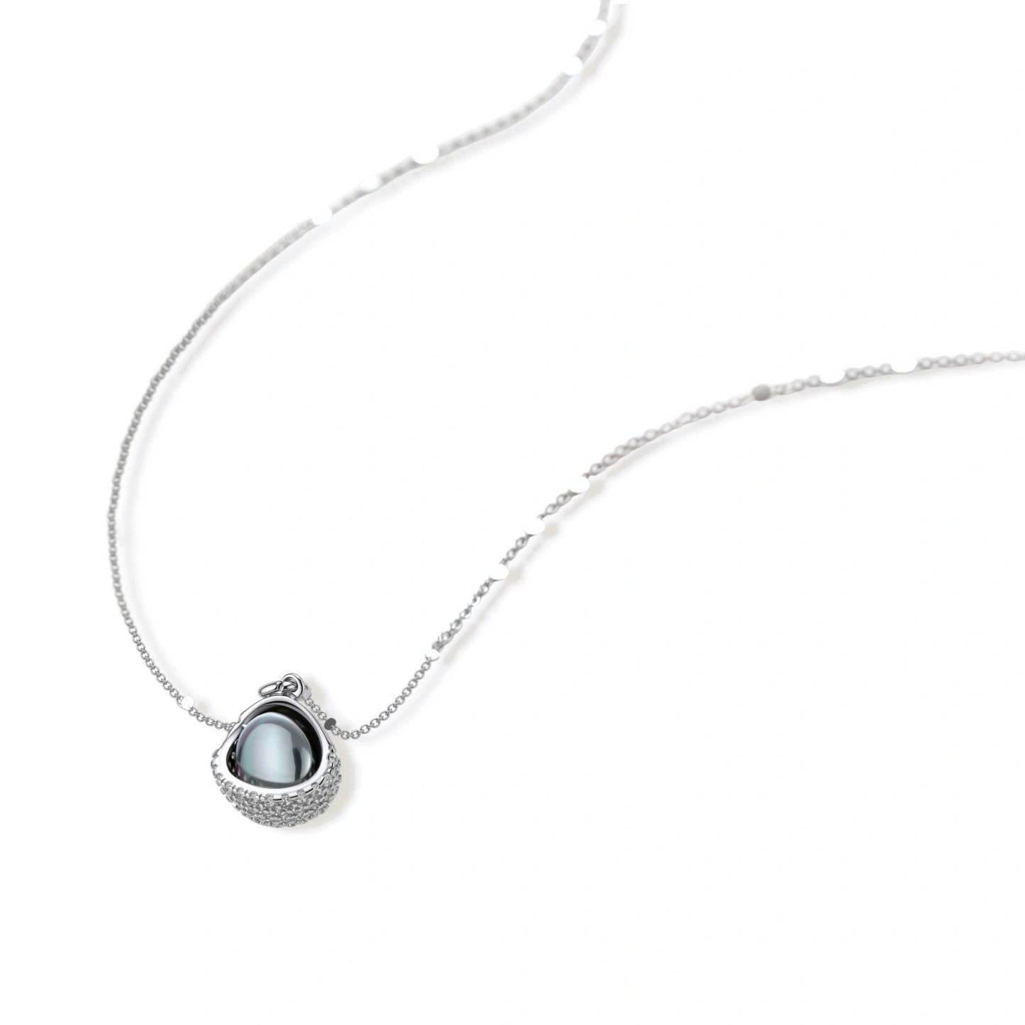 Silver gray Tahitian-style pearl pendant necklace and matching pave zirconia stud earrings set on cream background.