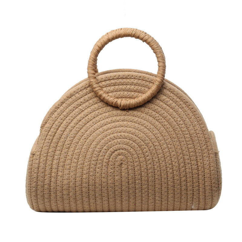 Beige woven handbag with circular handle on a white background