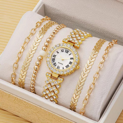 Gold watch and bracelets on a soft surface with a wooden box background