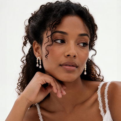 Woman wearing pearl earrings with a plain background