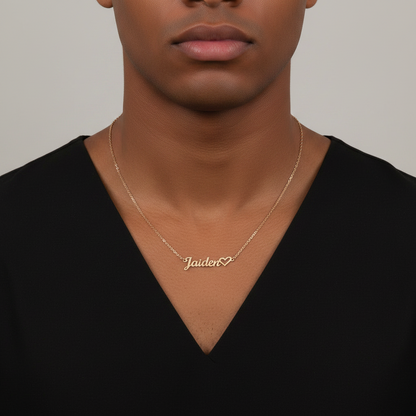 Young male wearing a silver necklace with a name pendant 'Jaiden' on a plain background