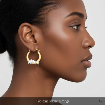 Two-tone Dolphin earrings on woman of color on a plain background