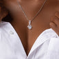 Silver necklace with a diamond pendant worn by a person in a white shirt.
