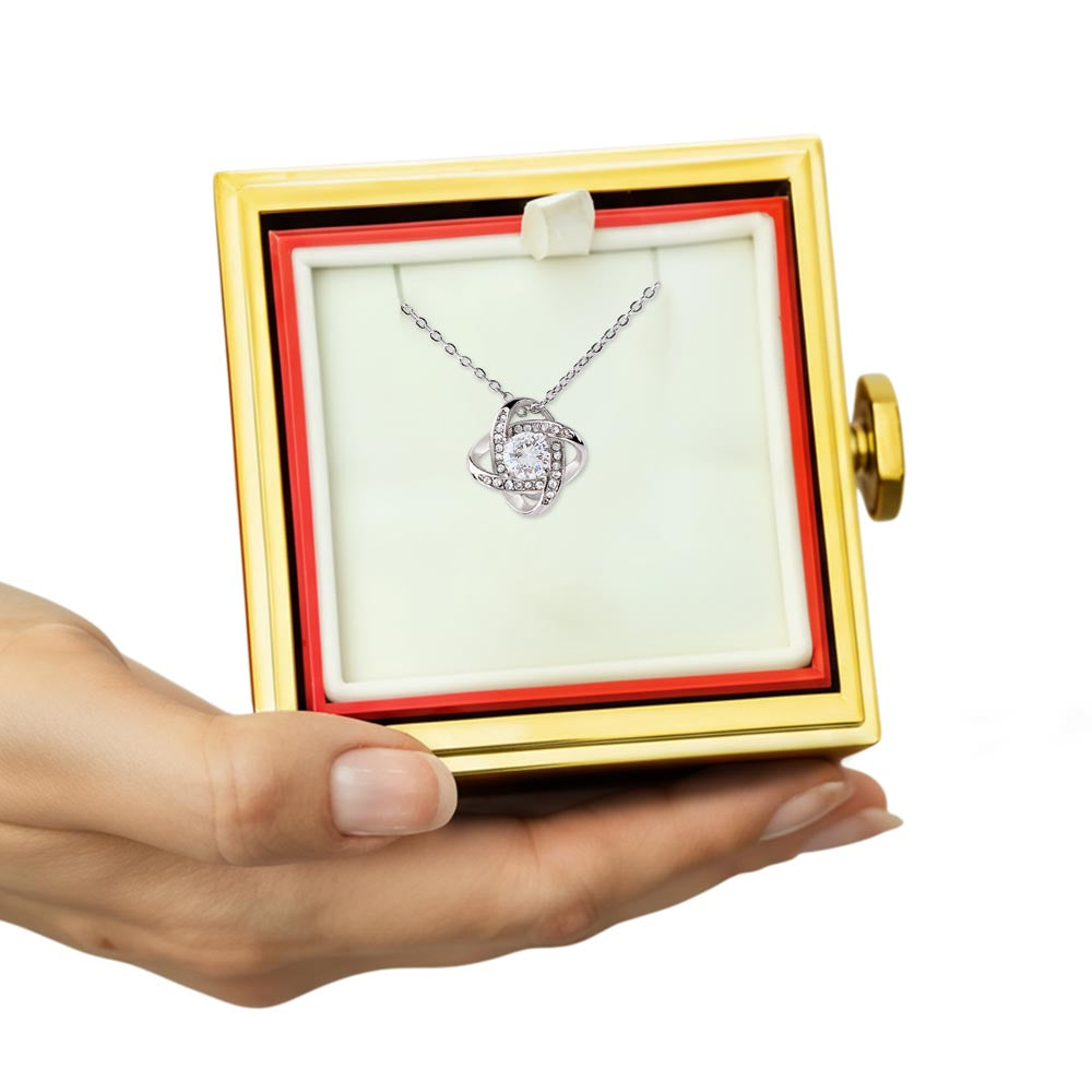 Rotating rose gift box open revealing love knot necklace inside