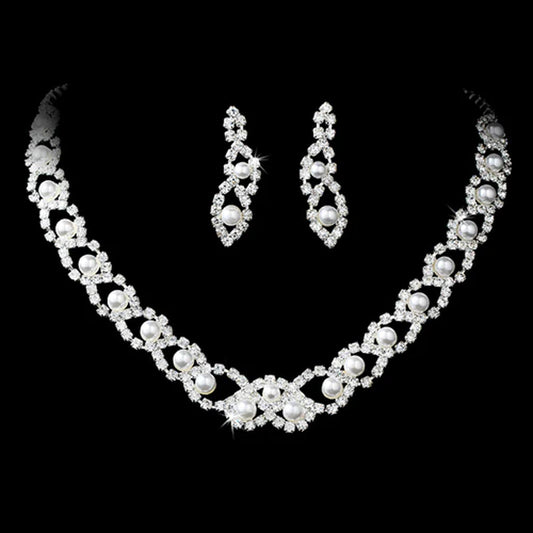 Elegant pearl and rhinestone bridal necklace and earring set displayed on black velvet